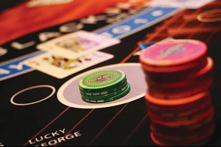 Ficha y cartas de blackjack para ilustrar estrategias de apuesta conservadoras