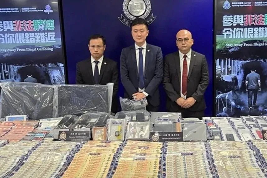 Agentes de Hong Kong muestran dinero y objetos incautados tras una operación contra una red ilegal de apuestas deportivas